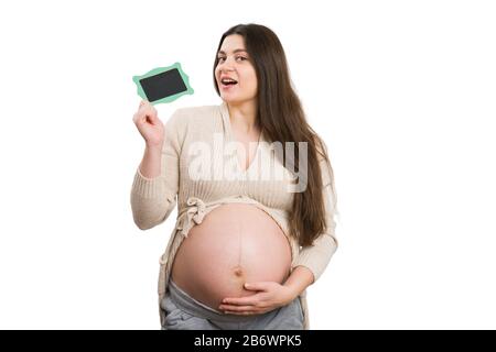 Femme enceinte montrant un mini tableau noir isolé sur fond blanc Banque D'Images