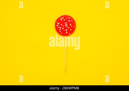 Un grand Lollipop rouge, sur un fond jaune. Banque D'Images