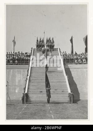 Jeugdstorm à Stadion Galgenwaard Jeugdstorm (servietitel) une longue lignée de membres de la tempête de jeunes qui descendent dans les escaliers du stade Galgenwaard à Utrecht le 20 juin 1942. Dans le stade, ils assisteront à l'inauguration de 3 000 cadres du NSB. En bas des escaliers se trouve un soldat Wehrmacht avec un drapeau. Dans les tribunes, la gauche et la droite de la scène sont membres de la tempête de jeunes. Certains apportent le salut de la NSB: Bras droit comme le salut et le chagage d'Hitler: Le mal. La cérémonie de serment est le résultat d'un compromis entre les Allemands et la NSB. Les Allemands voulaient un serment devant Hitler (que Mussert Banque D'Images