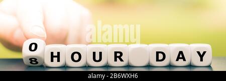 La main fait tourner les dés et change l'expression 'jour de 8 heure' en 'jour de 0 heure'. Banque D'Images