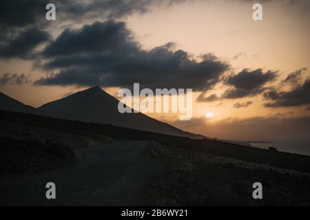 Coucher de soleil à la plage de Cofete avec une montagne énorme et ciel nuageux Banque D'Images