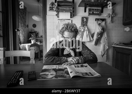 Italie, Lombardie, Casorezzo, Coronavirus, Covid 19, femme âgée qui lit un magazine Banque D'Images