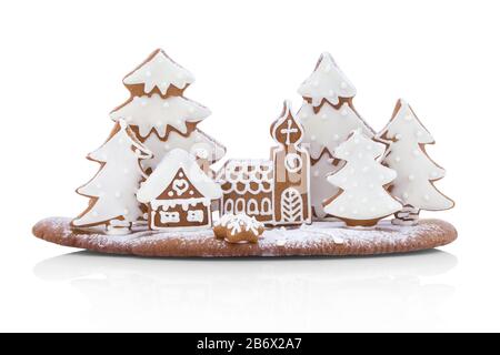 Maison et église en pain d'épices dans la forêt de conifères. Petit village maison dans la forêt créée à partir de miel. Décoration de Noël. Isolé sur blanc Banque D'Images