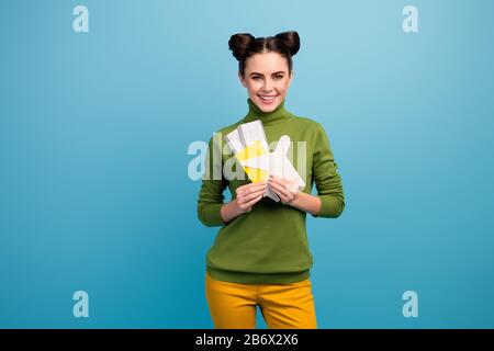 Photo d'une jolie dame porte des billets d'avion en papier pour les avions qui conseillent le voyage en avion accro voyageur porter un pantalon vert turtleneck jaune Banque D'Images