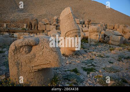 Ptah, Apollon et Déesse de Kommagene (Tyche) - têtes de statues sur le Mont Nemrut de West Terrace. Le monticule funéraire et le ciel bleu sont en arrière-plan. Banque D'Images