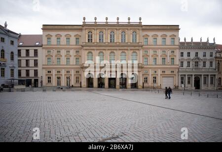 12 mars 2020, Brandebourg, Potsdam: Passants à pied après le musée Barberini sur la place du Vieux marché. Afin de protéger les clients et les employés d'une éventuelle infection par le virus corona, le musée Barberini avait déjà sérieusement limité le nombre de visiteurs la semaine dernière. Cependant, puisque le musée n'a pas pu accueillir la grande exposition publique 'Monet. Orte' avec initialement 2500 à 3000 visiteurs par jour, le musée ne peut garantir la limite recommandée de 500 à 1000 visiteurs lors d'événements culturels, le musée sera fermé du 12.03.2020 au 17.03.2020 inclusivement. Photo: Soeren Stache Banque D'Images