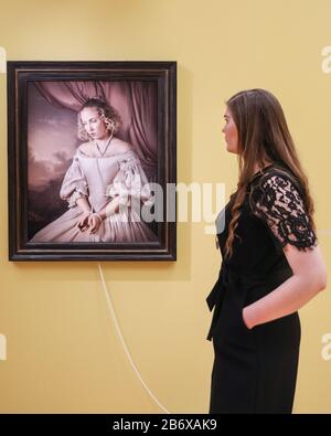 Londres, Royaume-Uni. 12 mars 2020. Un assistant pose avec la série « Shackled » de Maisie Broadhead, de la série Pearls, 2016 . « l'intérieur enchanté » remet en question la représentation historique des femmes dans l'art avec des œuvres d'artistes pré-Raphaël et contemporains féminins. L'exposition se déroule du 13 mars au 14 juin 2020. Crédit: Imagetraceur/Alay Live News Banque D'Images