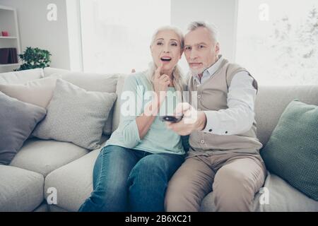 Famille de deux personnes âgées couple passer du temps libre ensemble changer de chaînes de recherche favori spectacle assis confortable canapé Banque D'Images