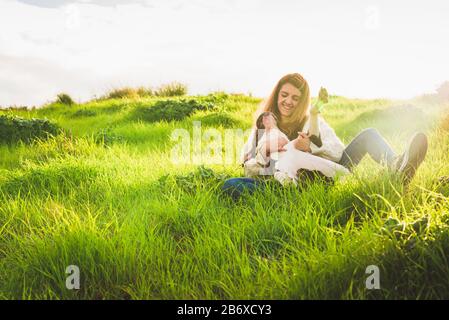 Jeune femme avec maillot blanc et jeans jouant avec le terrier américain du Staffordshire sur le terrain Banque D'Images