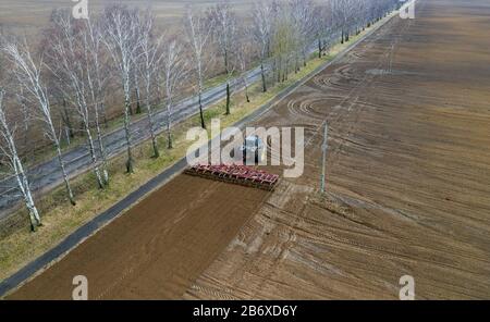 Vue de dessus de l'antenne d'un tracteur, moissonneuse-batteuse, de labourer les terres agricoles au printemps Banque D'Images