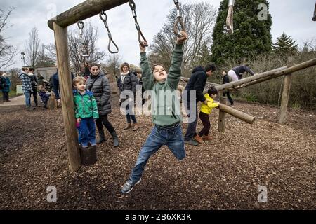 Les garçons actifs grimpent sur la RHS Retour à la zone d'activités en plein air du jardin de la nature à RHS Wisley co-conçu par La duchesse de Cambridge, Surrey, Angleterre, Royaume-Uni Banque D'Images