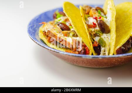 Coquilles de tacos mexicaines avec haricots rouges et de poulet, oignons, poivrons rouges et verts, sauce salsa, nourriture latine Banque D'Images