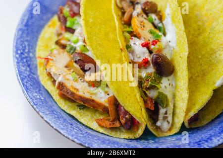 Coquilles de tacos mexicaines avec haricots rouges et de poulet, oignons, poivrons rouges et verts, sauce salsa, nourriture latine Banque D'Images