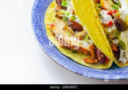 Coquilles de tacos mexicaines avec haricots rouges et de poulet, oignons, poivrons rouges et verts, sauce salsa, nourriture latine Banque D'Images