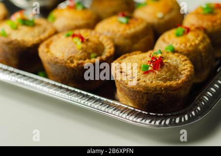 Tartes de porc anglais traditionnelles avec sauce aux canneberges sur un plateau argent, cuisine anglaise Banque D'Images