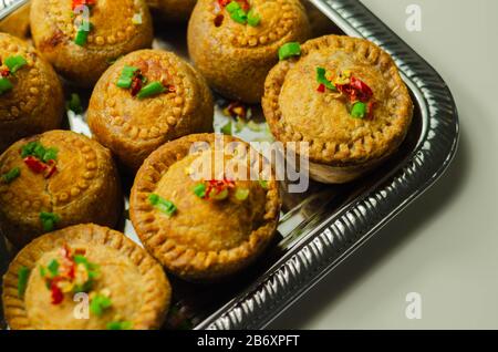 Tartes de porc anglais traditionnelles avec sauce aux canneberges sur un plateau argent, cuisine anglaise Banque D'Images