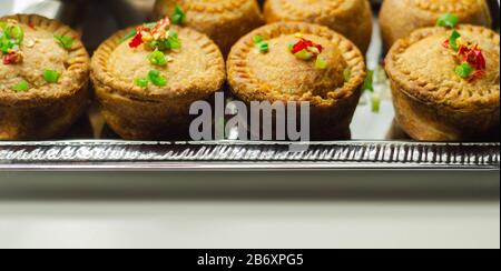 Tartes de porc anglais traditionnelles avec sauce aux canneberges sur un plateau argent, cuisine anglaise Banque D'Images