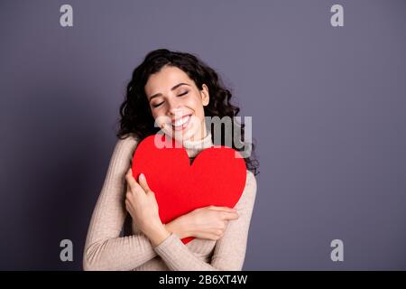 Gros plan photo belle elle sa dame overjoyed mains bras tenir grand papier rouge forme coeur figure fermeture poitrine invitation date prom porter décontracté Banque D'Images