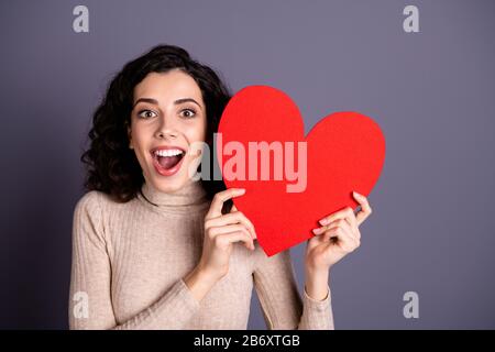 Gros plan photo positif belle elle sa belle dame mains bras tenir grand papier rouge forme coeur figure cool invitation date prom porter décontracté Banque D'Images