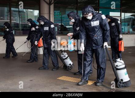 Séoul, Corée Du Sud. 12 mars 2020. Les soldats de l'armée sud-coréenne portant des combinaisons de protection vaporisaient un désinfectant pour empêcher la propagation du coronavirus (COVIS-19) au terminal de bus Ex-Press à Séoul, en Corée du Sud, le 12 mars 2020. (Photo de Lee Young-ho/Sipa USA) crédit: SIPA USA/Alay Live News Banque D'Images
