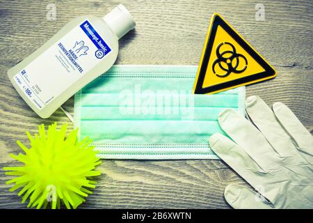 Mundschutz, Biogefaehrdungsschild, Schutzhandschuhe und Desinfektionsmittel auf einem Tisch, Symbolfoto Coronavirus Banque D'Images