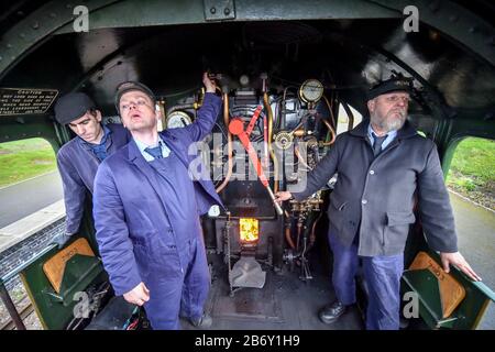 L'équipage du repose-pied contrôle la ligne à bord de la locomotive à vapeur Foremarke Hall du Great Western Railway Modifield Hall Classe 7903, construite en 1949, qui transporte les passagers de la gare de Toddington aux courses de Cheltenham pendant le festival. Banque D'Images