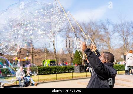 Central Park, New York - 8 mars 2020: Des fabricants de bulles géantes pour les touristes enchantés dans Central Park. Banque D'Images