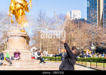 Central Park, New York - 8 mars 2020: Des fabricants de bulles géantes pour les touristes enchantés dans Central Park. Banque D'Images