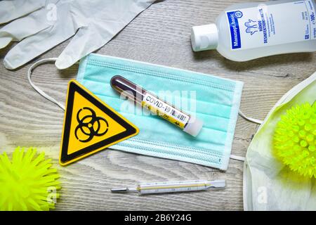Mundschutz, Blutentnahmeroehrchen, Biogefaehrdungsschild, Schutzhandschuhe und Desinfektionsmittel auf einem Tisch, Symbolfoto Coronavirus Banque D'Images
