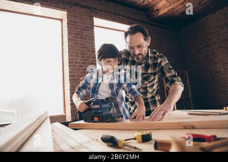 Vue à angle bas de deux beau concentré concentré inspiré personne maître constructeur père enseignant fils expliquant la formation réparation de bâtiment Banque D'Images