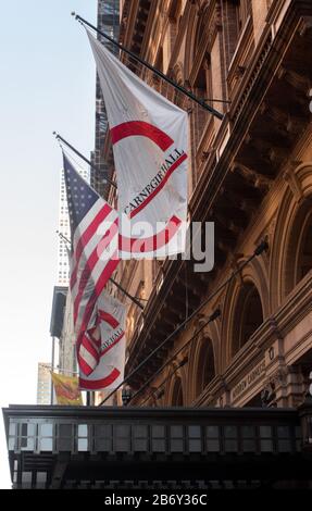 La bannière logo de Carnegie Hall se trouve aux côtés du drapeau américain au-dessus de l'entrée de Carnegie Hall, un monument national américain Banque D'Images