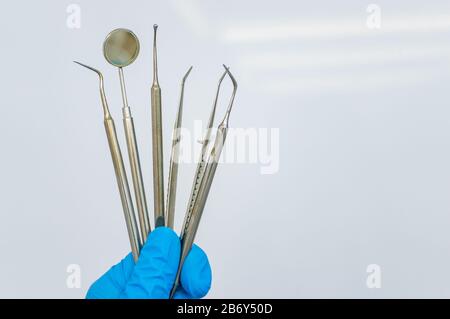 Outils dentaires à la main d'un médecin. Espace de copie Banque D'Images