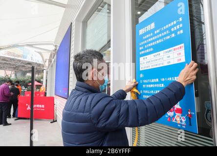 Shanghai. 12 mars 2020. Un membre du personnel affiche des informations sur les réductions de billets à l'entrée de la tour des perles orientales de Shanghai, dans l'est de la Chine, le 12 mars 2020. La tour de Shanghai, le bâtiment le plus élevé de Chine, a rouvert son attraction touristique « Top of Shanghai Observatory » à partir de jeudi. Deux autres sites touristiques ont également commencé à recevoir des touristes de jeudi, dont la tour des perles orientales de Shanghai et la tour Jinmao de Shanghai. POUR ALLER AVEC les paysages de gratte-ciel de 'Hanghai, les monuments à rouvrir' crédit: Ding Ting/Xinhua/Alay Live News Banque D'Images