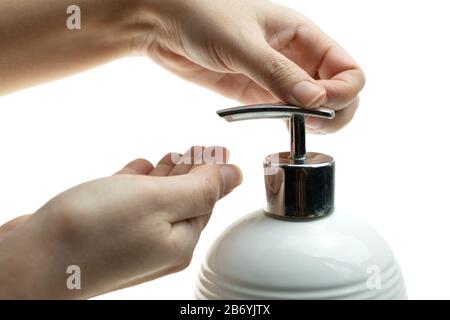 Fermez la lotion de pompage pour la main de la femme du biberon un savon liquide fouet sur fond blanc, Lady utilisant du gel d'alcool comme désinfectant pour les mains, Beau f Banque D'Images