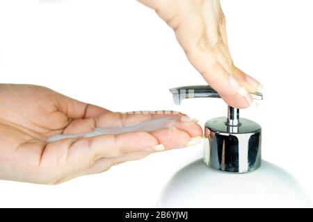 Lotion de pompage pour les mains des femmes du biberon savon liquide fouet à fond blanc, Lady utilisant du gel d'alcool comme désinfectant pour les mains, Belle main féminine esprit Banque D'Images