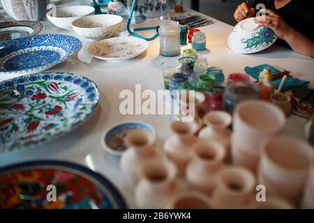 Peinture de plaques en porcelaine avec les mains d'un artisan professionnel. Artisanat turc national. Banque D'Images