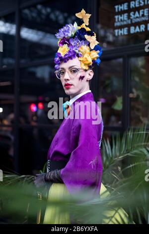 Londres, Royaume-Uni- febryary 15 2020: Les gens à la mode dans la rue . Style de rue. Un homme dans un kimono violet avec un produit de forme brillant et une couronne en yell Banque D'Images