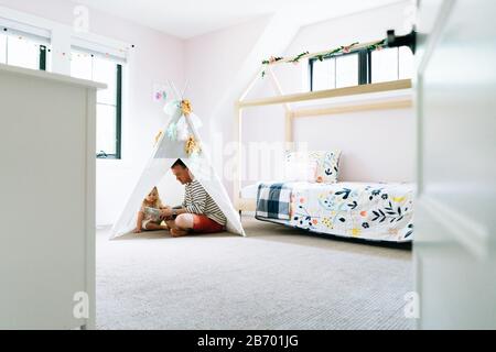 Vue panoramique sur un père et une fille assis ensemble dans un tipi d'enfant Banque D'Images