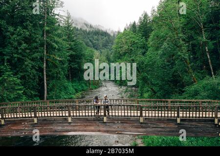 Un jeune couple profite d'une randonnée sur un pont dans le Nord-Ouest du Pacifique. Banque D'Images