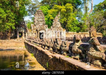 West gate et pont Naga aux ruines du temple Prasat Preah Khan, Angkor, site classé au patrimoine mondial de l'UNESCO, province de Siem Reap, Cambodge Banque D'Images