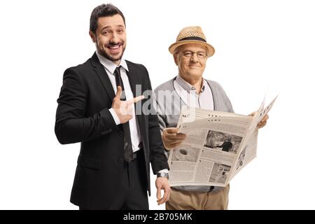 Jeune homme en costume riant et pointant vers un homme plus âgé avec un journal isolé sur fond blanc Banque D'Images