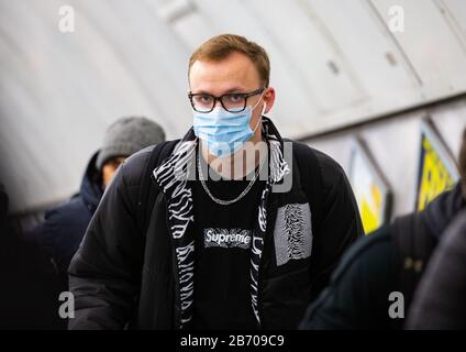 Un homme portant un masque sur le métro de Londres. La peur du Coronavirus se répand rapidement à mesure que les chiffres se développent avec des cas confirmés. Banque D'Images