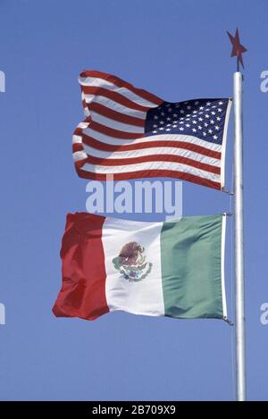 Brownsville Texas USA: Drapeaux américains et mexicains volant ensemble sur le mât de la ville à la frontière entre les États-Unis et le Mexique. ©Bob Daemmrich / Banque D'Images