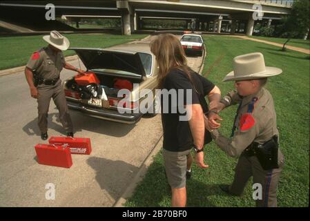 Austin Texas USA, 1997: Les policiers de l'État arrêtent un homme avec des outils volés dans le coffre de sa voiture dans un incident simulé MR ©Bob Daemmrich Banque D'Images