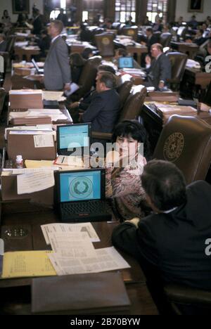 Austin, Texas États-Unis, 1997: Représentant d'État, Leticia Van de Putte de San Antonio avec ordinateur portable à son bureau sur le plancher de la Chambre des représentants du Texas pendant la session législative. ©Bob Daemmrich Banque D'Images