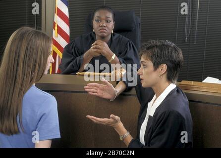 Austin Texas USA, 1997: Une avocate hispanique féminine parle à son client avant que la juge afro-américaine de district condamne la défenderesse. M. ©Bob Daemmrich Banque D'Images