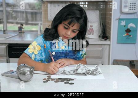 Austin Texas États-Unis, 1998 : huit ans, une jeune fille panaméenne-américaine prépare le dépôt pour le compte d'épargne à partir de dollars et de pièces qu'elle a économisé.. MR ©Bob Da Banque D'Images