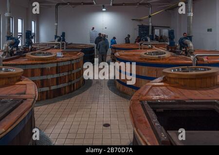 Personnes près des réservoirs de fermentation de la distillerie Talisker Banque D'Images