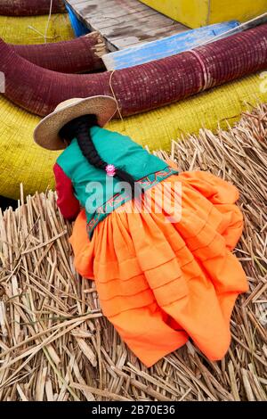 Femme locale qui liait un bateau à roseau sur l'île flottante d'Uros, Lago Titicaca, Pérou Banque D'Images