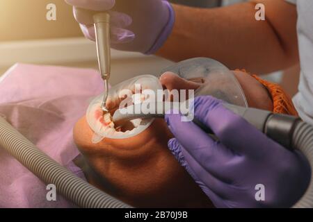 Le patient visite le dentiste pour une procédure d'échographie dentaire dans une clinique dentaire.2020 Banque D'Images